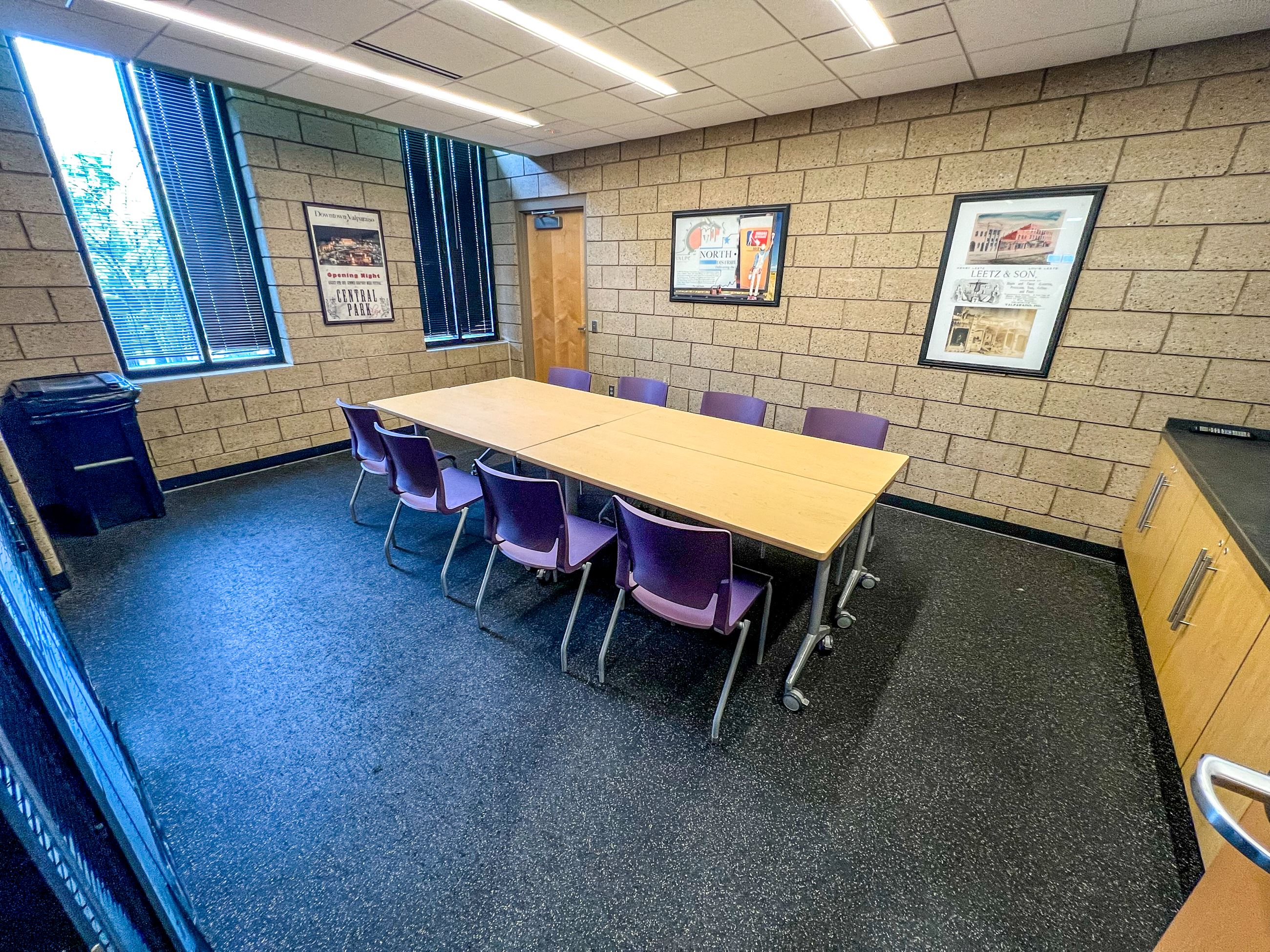 table with eight surrounding chairs in center of conference room at Indiana Beverage Center